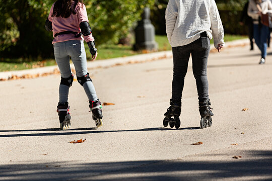 Dos chicas adolescentes patinando con patines en l&iacute;nea.