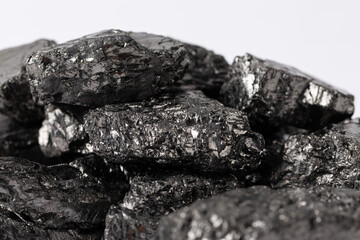 Fototapeta premium Heap of natural black fossil coal on a white isolated background.