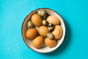 Eggs in a bowl on blue background