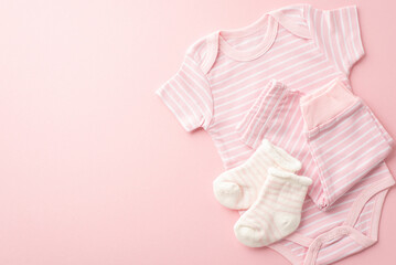 Baby concept. Top view photo of pink infant clothes bodysuit pants and tiny socks on isolated pastel pink background with empty space