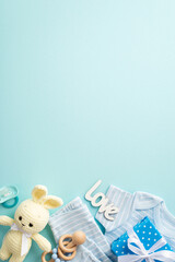 Baby concept. Top view vertical photo of giftbox infant clothes blue shirt pants inscription love knitted bunny toy wooden rattle and pacifier on isolated pastel blue background with copyspace