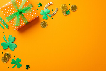 Saint Patrick's Day concept. Top view photo of big giftbox with bow gold coins horseshoe straws...