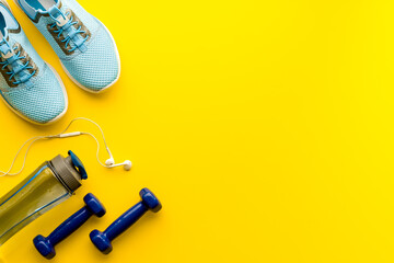 Sport background with sneakers and dumbbells, top view