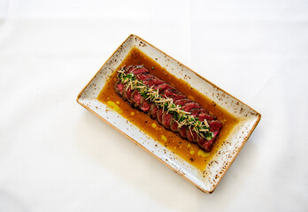 beef steak on a plate, on a white table