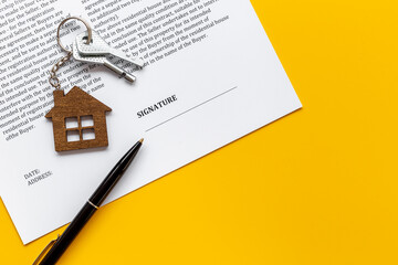 Signing a house purchase agreement concept with house shaped keychain