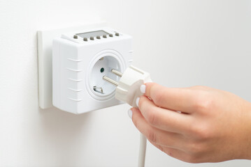 Inserting electric device plug to outlet computer. Using electricity, socket timer that turn on and...