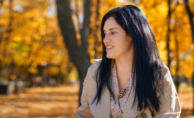 portrait of a woman in an autumn city park, beautiful nature, yellow maple leaves, bright sunny day