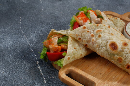 Shawarma chicken roll in a pita with fresh vegetables