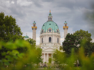Naklejka premium Catholic church located in the southern part of Karlsplatz, Vienna. One of the symbols of the city. The Karlskirche is a prime example of the original Austrian Baroque style. view across park
