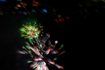 Obraz na płótnie Canvas Abstract photo of firework flower. Salute without focus. Blurry photo of firework. A beautiful flicker of green bokeh.