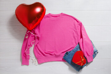 Pink sweatshirt mockup. Valentines Day concept shirt, balloon heart shape on wooden background. Copy space, template blank front view clothes. Romantic outfit. Flat lay birthday holiday fashion