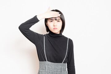 発熱で額に手を当てている若い女性