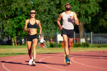 Obraz premium Woman and man jogging in the stadium