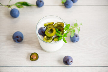 sweet homemade yogurt with fresh plum slices in a glass