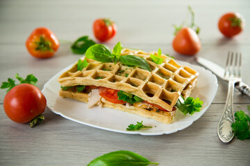 Sandwich of two egg omelettes with bacon and tomatoes inside