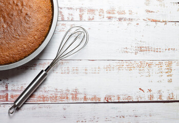 homemade sponge cake on wooden board and utensil, copy space