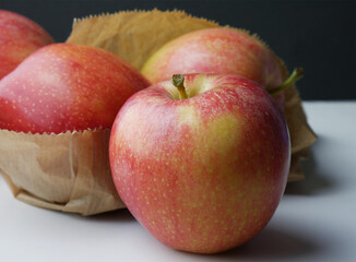 Close up, group of apples on light background and paper bag.