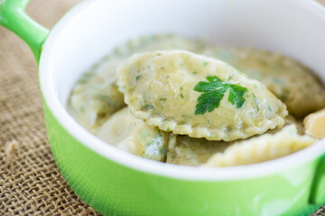 Boiled dumplings with stuffing inside, from dough with herbs
