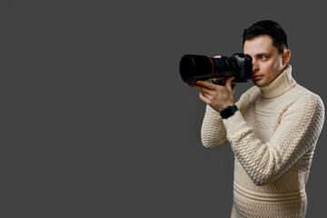 Professional photographer with a camera on gray background
