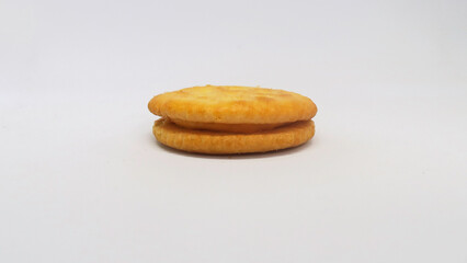 Cheese-coated biscuit seen from a side angle.