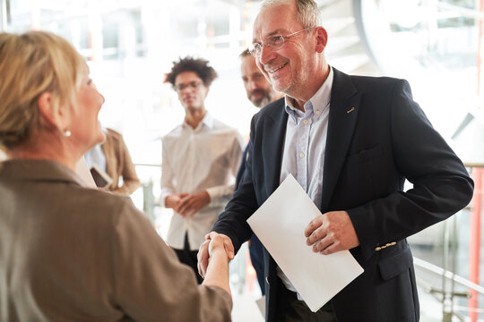 &Auml;lterer Business Mann als Manager beim H&auml;ndesch&uuml;tteln