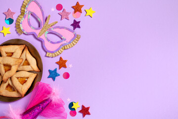 Purim carnival background with traditional cookies, costume accessories and decor on pastel violet