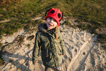 Cute little girl having fun in nature. A beautiful child poses outdoors on a sunny day in early spring.