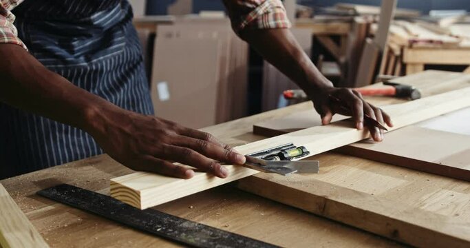 African carpenter measuring his working for his carpentry project
