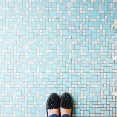 from where i see type of picture of a black shoes on top of vintage blue tiles