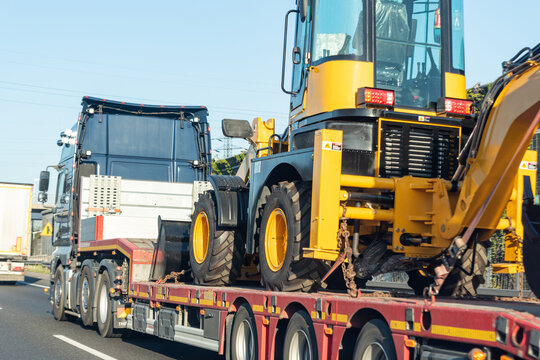 Warsaw, Poland - May 13, 2022: Transportation of construction machinery. Excavator on a trailer.