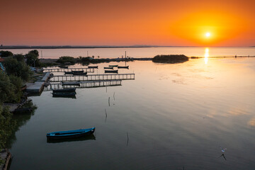 Aerial view of a beautiful sunrise in the harbour of Sarichioi village from Dobrogea, next to Razlem lake. Landmarks of Romania.
