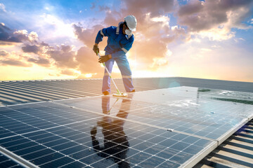 Man using a mop and water to clean the solar panels that are dirty with dust and birds' droppings...