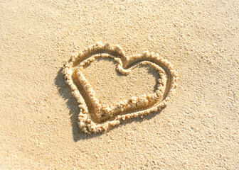 heart is drawn on beach sand. Painted heart on sand