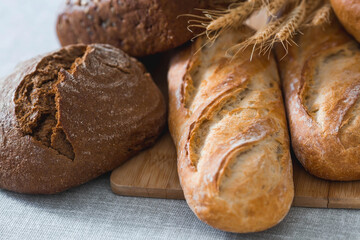 Fresh delicious bread close-up. Freshly baked sourdough bread with a golden crust on a wooden board. The context of a bakery with delicious bread. Confectionery products.