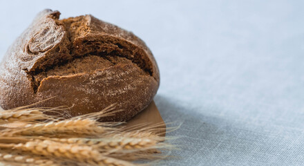 Fresh delicious bread close-up. Freshly baked sourdough bread with a golden crust on a wooden board. The context of a bakery with delicious bread. Confectionery products.