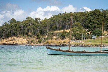 Naklejka na ściany i meble man watching wooden boat on the water, at the wooden boat festival in hobart tasmania australia