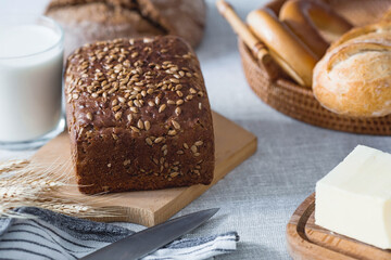 Fresh delicious whole grain rye bread with seeds close-up. Freshly baked bread on a wooden board. The context of a bakery with delicious bread. Confectionery products.