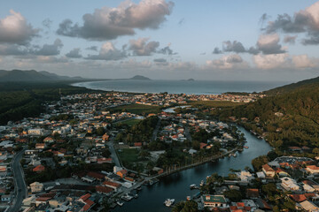 as Dorf - Stadt Barra da Lagoa. Ein Fluss mündet im Meer. Ein Dorf liegt direkt am Meer. Drohne Brasil 24
