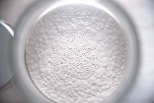 Surface of clay soaked in water. Life under the microscope. Circular formations on a white surface with cracks