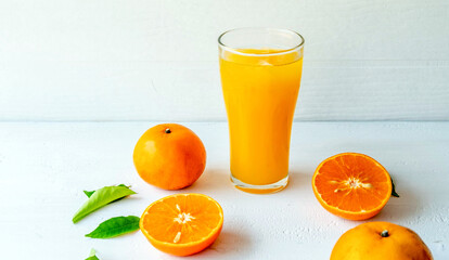 Freshly squeezed orange juice and orange fruit cut in half
