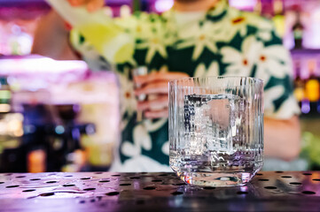 empty glass with ice on a bar counter in bar or pub