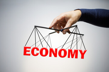 Businessman keeping the word economy. Concept of manipulation management economy.