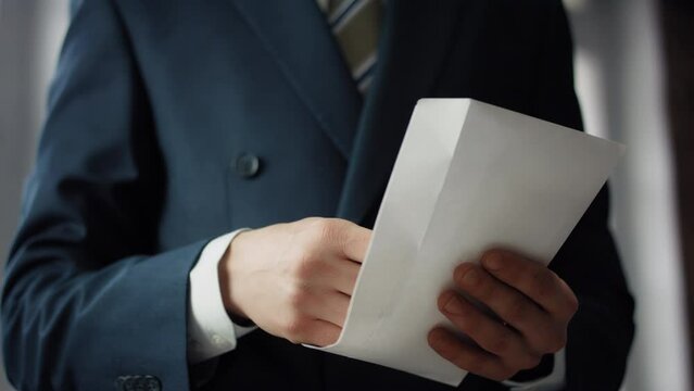 Hands holding bribe envelope containing euro cash close up. Financial crime.