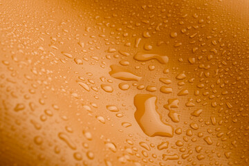 Orange waterproof material with waterdrops.  Close-up Photo of Water Drops. 