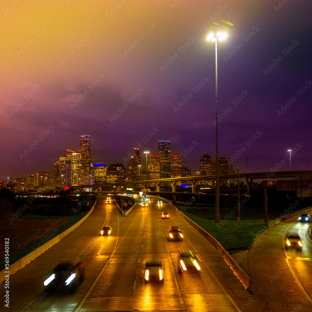 Wall mural Houston Downtown City Skyline in Golden Color at foggy night over Interstate 45 Freeway in Texas, USA, vibrant metropolis nightscape with motion blur light trails of cars on the highway