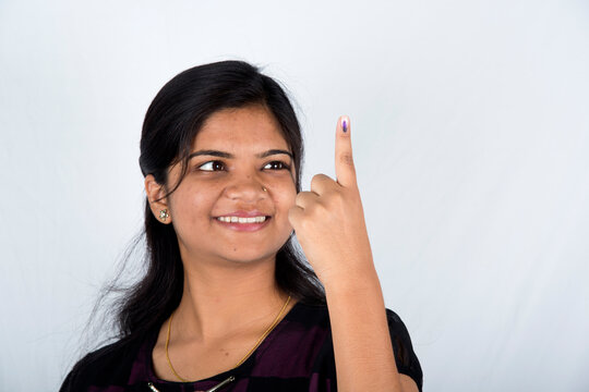 A indian young girl show her ink-marked fingers after casting vote in election.