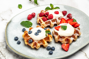 Berry Belgian Waffle with raspberries, strawberries and blueberries. Culinary, cooking, bakery concept. Food recipe background. Close up