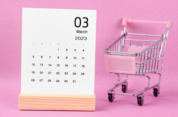 The March 2023 Monthly calendar with shopping cart against pink background.