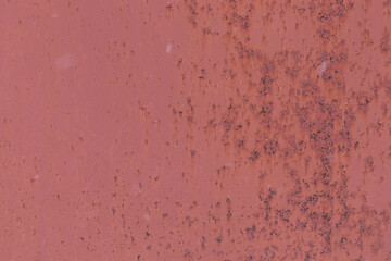 Part of the red painted metal door. Old rusted metal. Metal weathered surface. Close up view.