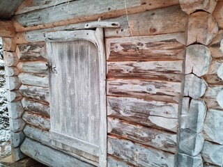 old wooden door on ancient grain milling house building in winter